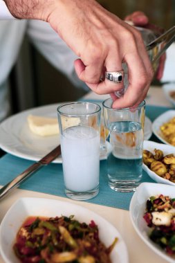 Özel Alkollü İçkili Rakılı Türk ve Yunan Geleneksel Yemek Masası. Uzo ve Türk Rakısı, Türkiye, Yunanistan, Kıbrıs ve Lübnan'da yaygın olarak tüketilen kuru anason aromalı bir aperatiftir.