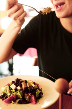 çekici beyaz salata, odak üstünde el yemek kadın ve çatal gülümseyen portresi.