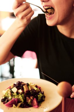 çekici beyaz salata, odak üstünde el yemek kadın ve çatal gülümseyen portresi.