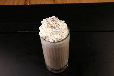 Sütlü buzlu kahve. Buzlu kahve. Elinde bir bardak buzlu kahve tutan kadın..