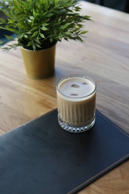 Sütlü buzlu kahve. Buzlu kahve. Elinde bir bardak buzlu kahve tutan kadın..