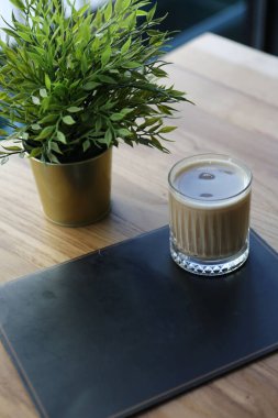 Sütlü buzlu kahve. Buzlu kahve. Elinde bir bardak buzlu kahve tutan kadın..