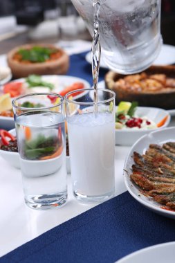 Özel Alkollü İçkili Rakılı Türk ve Yunan Geleneksel Yemek Masası. Uzo ve Türk Rakısı, Türkiye, Yunanistan, Kıbrıs ve Lübnan'da yaygın olarak tüketilen kuru anason aromalı bir aperatiftir.