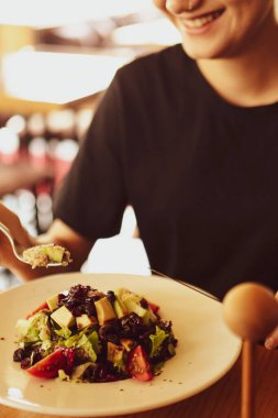 çekici beyaz salata, odak üstünde el yemek kadın ve çatal gülümseyen portresi.