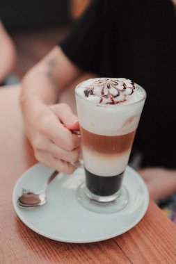 Sütlü buzlu kahve. Buzlu kahve. Elinde bir bardak buzlu kahve tutan kadın..