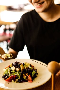 çekici beyaz salata, odak üstünde el yemek kadın ve çatal gülümseyen portresi.