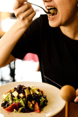 çekici beyaz salata, odak üstünde el yemek kadın ve çatal gülümseyen portresi.