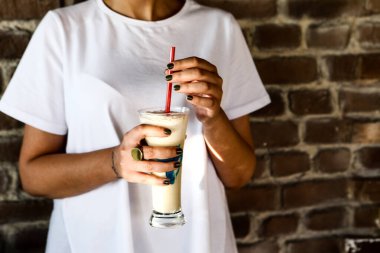 Sütlü buzlu kahve. Buzlu kahve. Elinde bir bardak buzlu kahve tutan kadın..