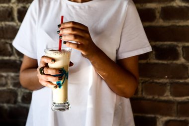 Sütlü buzlu kahve. Buzlu kahve. Elinde bir bardak buzlu kahve tutan kadın..