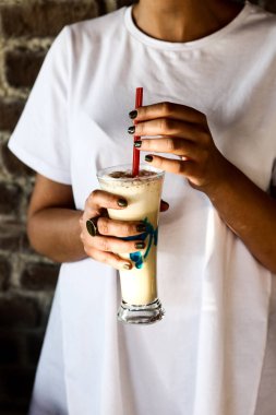 Sütlü buzlu kahve. Buzlu kahve. Elinde bir bardak buzlu kahve tutan kadın..