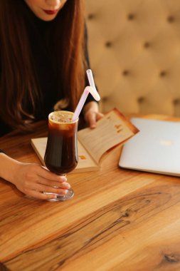 Sütlü buzlu kahve. Buzlu kahve. Elinde bir bardak buzlu kahve tutan kadın..