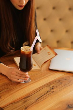 Sütlü buzlu kahve. Buzlu kahve. Elinde bir bardak buzlu kahve tutan kadın..