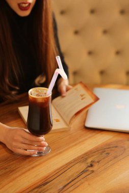 Sütlü buzlu kahve. Buzlu kahve. Elinde bir bardak buzlu kahve tutan kadın..