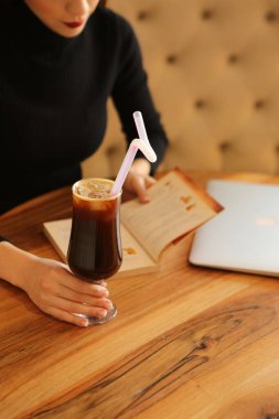 Sütlü buzlu kahve. Buzlu kahve. Elinde bir bardak buzlu kahve tutan kadın..