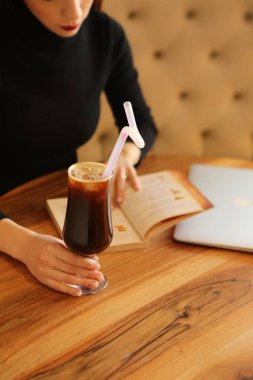 Sütlü buzlu kahve. Buzlu kahve. Elinde bir bardak buzlu kahve tutan kadın..