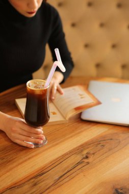 Sütlü buzlu kahve. Buzlu kahve. Elinde bir bardak buzlu kahve tutan kadın..