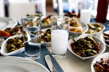 Özel Alkollü İçkili Rakılı Türk ve Yunan Geleneksel Yemek Masası. Uzo ve Türk Rakısı, Türkiye, Yunanistan, Kıbrıs ve Lübnan'da yaygın olarak tüketilen kuru anason aromalı bir aperatiftir.