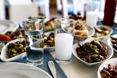 Özel Alkollü İçkili Rakılı Türk ve Yunan Geleneksel Yemek Masası. Uzo ve Türk Rakısı, Türkiye, Yunanistan, Kıbrıs ve Lübnan'da yaygın olarak tüketilen kuru anason aromalı bir aperatiftir.