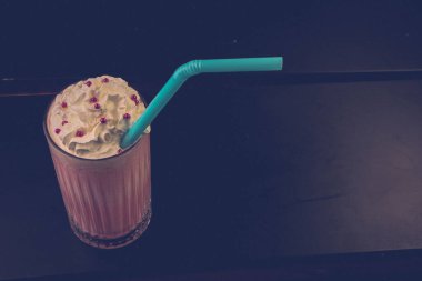 Bir bardak ahududu milkshake, krem şanti ve taze ahududu.