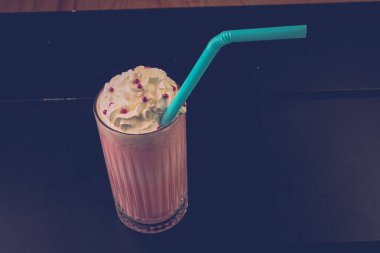 Bir bardak ahududu milkshake, krem şanti ve taze ahududu.
