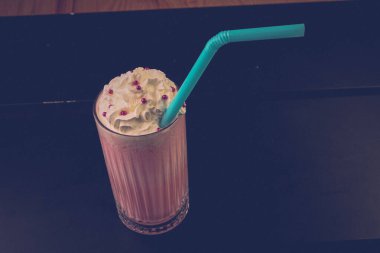 Bir bardak ahududu milkshake, krem şanti ve taze ahududu.
