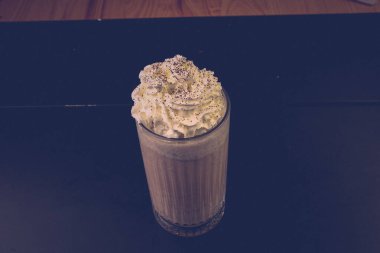 Bir bardak ahududu milkshake, krem şanti ve taze ahududu.