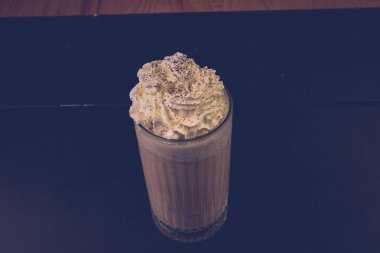 Bir bardak ahududu milkshake, krem şanti ve taze ahududu.