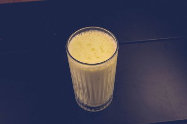 Bir bardak ahududu milkshake, krem şanti ve taze ahududu.