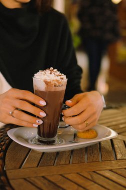 Sütlü buzlu kahve. Buzlu kahve. Elinde bir bardak buzlu kahve tutan kadın..