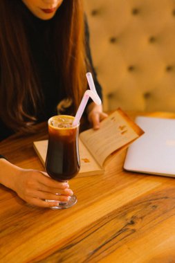 Sütlü buzlu kahve. Buzlu kahve. Elinde bir bardak buzlu kahve tutan kadın..