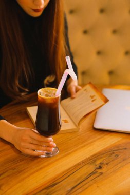 Sütlü buzlu kahve. Buzlu kahve. Elinde bir bardak buzlu kahve tutan kadın..