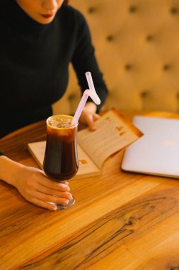 Sütlü buzlu kahve. Buzlu kahve. Elinde bir bardak buzlu kahve tutan kadın..