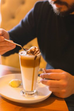 Sütlü buzlu kahve. Buzlu kahve. Elinde bir bardak buzlu kahve tutan kadın..