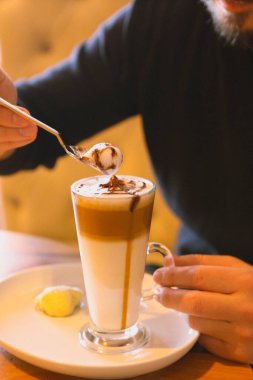 Sütlü buzlu kahve. Buzlu kahve. Elinde bir bardak buzlu kahve tutan kadın..