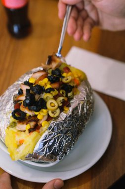 Peynir, sosis, zeytin, biber ve Mısır ile pişmiş kumpir patates dolması