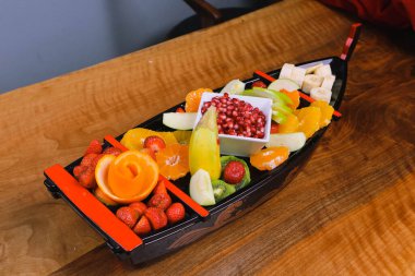 Lezzetli karışık meyveler ve dilimlenmiş meyvelerle dolu bir tabak.