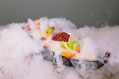 Lezzetli karışık meyveler ve dilimlenmiş meyvelerle dolu bir tabak.