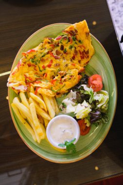 Lezzetli omlet ve kahvaltı tabağı masada..