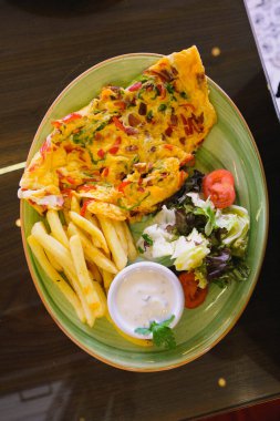 Lezzetli omlet ve kahvaltı tabağı masada..