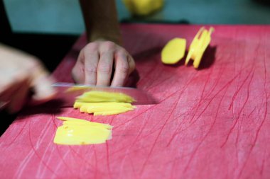 İnsan yemek pişirmek için patatesleri doğrar..
