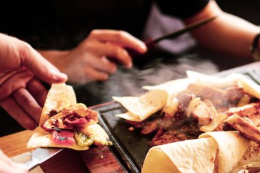 Genç bir kadın lezzetli, taze Hint yemekleri yer.