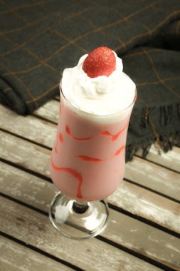 Bir bardak ahududu milkshake, krem şanti ve taze ahududu.