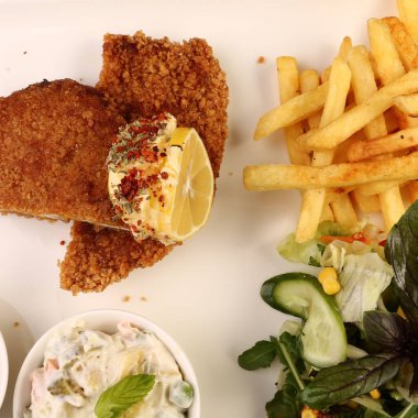 Patates kızartmasıyla servis edilen lezzetli şnitzel.