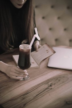 Kitap ya da dergi okurken bir fincan kahve.