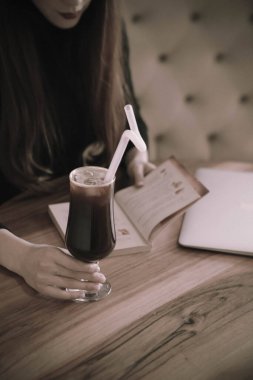 Kitap ya da dergi okurken bir fincan kahve.