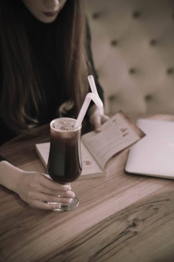 Kitap ya da dergi okurken bir fincan kahve.