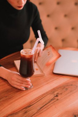 Kitap ya da dergi okurken bir fincan kahve.