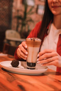Sütlü buzlu kahve. Buzlu kahve. Elinde bir bardak buzlu kahve tutan kadın..