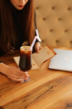 Kitap ya da dergi okurken bir fincan kahve.