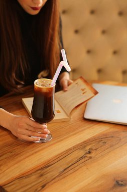 Kitap ya da dergi okurken bir fincan kahve.